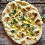To make easy garlic naan bread, gather these simple ingredients: - 2 cups all-purpose flour - 1 teaspoon sugar - 1 teaspoon salt - 1 teaspoon baking powder - 1 tablespoon plain yogurt - 2 tablespoons milk - 3/4 cup warm water - 2 tablespoons minced garlic (about 4 cloves) - 2 tablespoons melted butter - Optional: Fresh cilantro for garnish Each ingredient plays a key role. Flour gives naan its structure, while the yogurt helps make it soft. The garlic adds flavor, making each bite special. Sugar and salt balance the taste, and baking powder helps it rise. Warm water activates the yeast, creating a light texture. If you want, fresh cilantro adds a pop of color and taste. This list is all you need to whip up delicious garlic naan. You can find the full recipe in the article. Enjoy cooking! - Mixing dry ingredients: Start by taking a large bowl. Add 2 cups of all-purpose flour, 1 teaspoon of sugar, 1 teaspoon of salt, and 1 teaspoon of baking powder. Whisk these together until they blend well. This will form the base for your naan. - Forming the dough: Make a well in the center of the dry mix. Pour in 1 tablespoon of plain yogurt and 3/4 cup of warm water. Stir with a spoon until the mixture forms a rough dough. - Kneading the dough: Transfer the dough to a clean, floured surface. Knead it for about 5 to 7 minutes. The goal is to make it soft and smooth. If it sticks, add a bit more flour. - Covering the dough: Place the kneaded dough in a greased bowl. Use a damp cloth or plastic wrap to cover it. This keeps the moisture in as it rises. - Timeframe for dough to double in size: Let the dough sit in a warm area for about 1 hour. You’ll know it’s ready when it has doubled in size. - Rolling out the dough: After rising, gently punch down the dough. Divide it into 6 equal pieces. Roll each piece into a ball. Take a ball and roll it out into an oval shape about 1/4 inch thick. - Cooking sequence on skillet: Preheat a skillet over medium-high heat. Brush the top of the rolled naan with melted butter. Sprinkle 2 tablespoons of minced garlic evenly on top. - Tips for achieving golden brown color: Place the naan in the hot skillet, garlic side up. Cook for 2-3 minutes until bubbles form. Flip it over and cook for another 1-2 minutes. Look for a golden brown color before taking it off the heat. Enjoy making this Easy Garlic Naan Bread! For the complete set of instructions, refer to the Full Recipe. To get the best naan, start with the right dough. The texture should be soft and smooth. If it feels sticky, add more flour slowly. Knead it well; this helps the dough rise. Timing is key when cooking. Don't rush it! Let the dough rise fully for the best texture. Cook each naan just until it bubbles, then flip to brown it. You can add fun flavors to your naan! Try mixing in spices like cumin or sesame seeds. They add a nice crunch and depth. If you want a twist, experiment with different garlic types. Roasted garlic gives a sweet taste, while fresh garlic is strong and zesty. Adding herbs like parsley or thyme can also change the flavor profile. For cooking, a skillet or tawa works best. A heavy-bottomed skillet holds heat well. If you don’t have a tawa, any flat pan will do. You can also use an oven. Preheat it high and bake the naan on a hot stone. Grilling is another option for a smoky taste. Just make sure to watch it closely! For the complete recipe, check out the Full Recipe section. {{image_4}} You can make naan even more fun with flavors. Here are some tasty ideas: - Cheesy garlic naan: Add shredded cheese on top of the garlic before cooking. Mozzarella or cheddar works well. The cheese melts and adds a creamy taste. - Herb-infused naan: Mix dried or fresh herbs like basil or oregano into the dough. This gives a fresh taste that pairs well with any meal. Do you need to change the recipe for diets? Here are some options: - Gluten-free naan: Use gluten-free flour blends instead of all-purpose flour. Make sure the blend has xanthan gum for the right texture. - Vegan modifications: Substitute yogurt with plant-based yogurt. You can replace butter with olive oil or coconut oil to keep it vegan-friendly. Feel free to try these variations to make the recipe your own. You can find the full recipe for garlic naan above. Enjoy experimenting! To keep your naan fresh, you need to store it right. First, let the naan cool completely after cooking. Then, you can wrap it in foil or plastic wrap. This keeps moisture in and prevents it from getting hard. Place the wrapped naan in the fridge if you plan to eat it soon. If you want to save naan for later, freezing is a great choice. Stack the naan with parchment paper between each piece. This prevents them from sticking together. Then, place the stack in a freezer bag. Squeeze out all the air before sealing. Naan can stay good in the freezer for up to three months. When you’re ready to eat your naan, there are a few ways to reheat it. The best method is to use a skillet. Heat the skillet over medium heat. Place the naan in the skillet for about 30 seconds on each side. This keeps the naan soft and warm. You can also use the oven. Preheat it to 350°F (175°C). Place the naan on a baking sheet and cover it with foil. Heat for about 10 minutes. This method also keeps the naan soft. Avoid the microwave if you can. It can make naan tough or dry. If you must use it, wrap the naan in a damp paper towel. Heat it for just 10-15 seconds. This helps retain some moisture, but it’s not as good as the other methods. For more tips and the full recipe, check out the Garlic Naan Delight section! Can I make garlic naan without yogurt? Yes, you can skip the yogurt. Substitute it with more water or milk. Yogurt adds flavor and helps the naan rise. Without it, the naan may be less soft. How can I make naan puff up more? To help naan puff up, ensure your dough is well-kneaded. A warm skillet also helps. When cooking, let the naan bubble before turning it over. What can I serve with garlic naan? Garlic naan pairs well with many dishes. Serve it with curries, stews, or dips. It also tastes great with yogurt or chutneys for added flavor. What to do if my dough doesn't rise? If your dough doesn't rise, check the yeast or baking powder. They may be old. Ensure your water is warm, not hot. A warm spot helps the dough rise better. Why is my naan sticking to the skillet? If naan sticks, your skillet may not be hot enough. Try using less dough on the skillet. A little oil can also help. Make sure to preheat your skillet well. Can I cook naan on a grill? Yes, you can cook naan on a grill. Preheat the grill and place the naan on it. Close the lid and cook until it puffs up and gets grill marks. How to adapt the recipe for an oven? To use an oven, preheat it to 500°F (260°C). Place the naan on a baking sheet lined with parchment paper. Bake for 4-5 minutes or until golden brown. The baking method is great for making more naan at once. To make garlic naan, you need simple ingredients and quick steps. Here’s what you will use: - 2 cups all-purpose flour - 1 teaspoon sugar - 1 teaspoon salt - 1 teaspoon baking powder - 1 tablespoon plain yogurt - 2 tablespoons milk - 3/4 cup warm water - 2 tablespoons garlic, minced (about 4 cloves) - 2 tablespoons butter, melted - Fresh cilantro, chopped (for garnish, optional) Start by mixing the dry ingredients in a bowl. Make a well and add yogurt and water. Stir until it forms a dough. Knead the dough for 5-7 minutes until it feels soft. Then, let it rise for one hour. Next, divide the dough into six balls. Roll each ball into a flat shape. Brush with butter and add minced garlic. Cook on a hot skillet for 2-3 minutes, flip, and cook for 1-2 more minutes. This recipe takes about 15 minutes to prep and 1 hour and 15 minutes in total. You can serve it warm with your favorite curry. Enjoy this garlic naan delight! You learned how to make delicious garlic naan from scratch. We covered the ingredients, step-by-step instructions, and tips for perfecting the naan. You can explore different flavors and dietary options too. Store your naan properly and reheat it to keep it soft. Making garlic naan is fun and rewarding. It brings joy to your meals. Enjoy trying this recipe and sharing your creations with family and friends. Happy cooking!